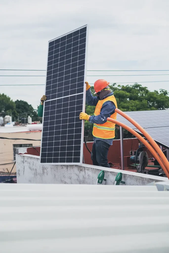 a solar panel installer holding a solar panel