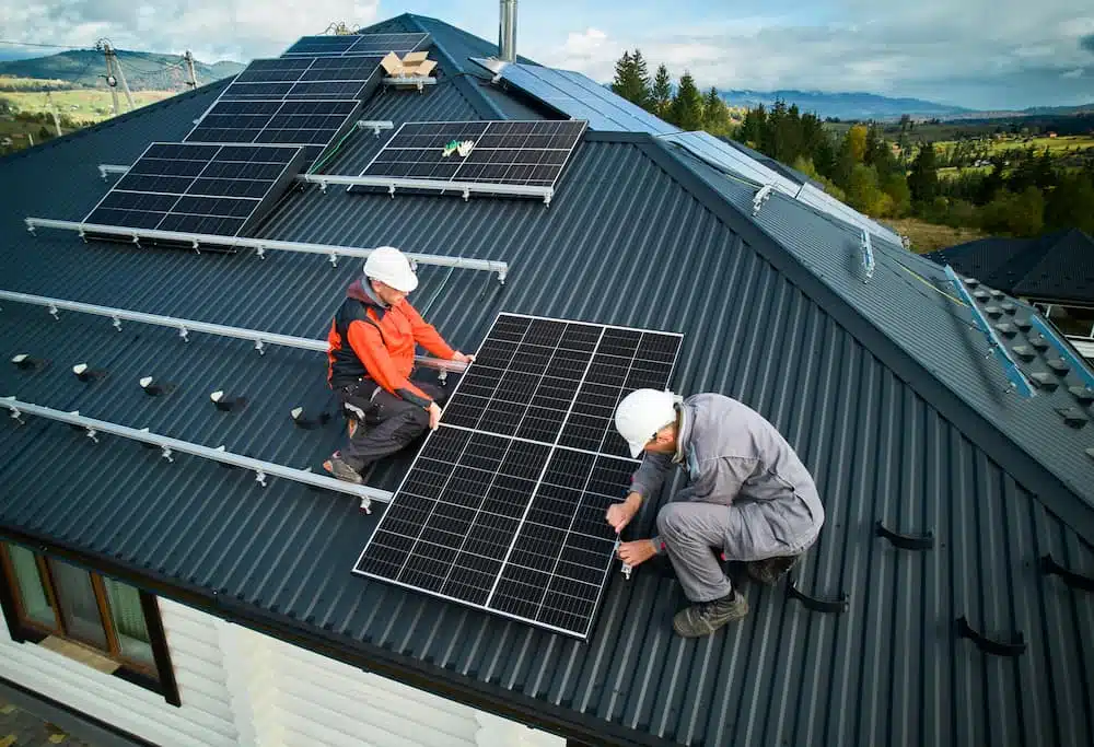 two men helping each other to install solar panel