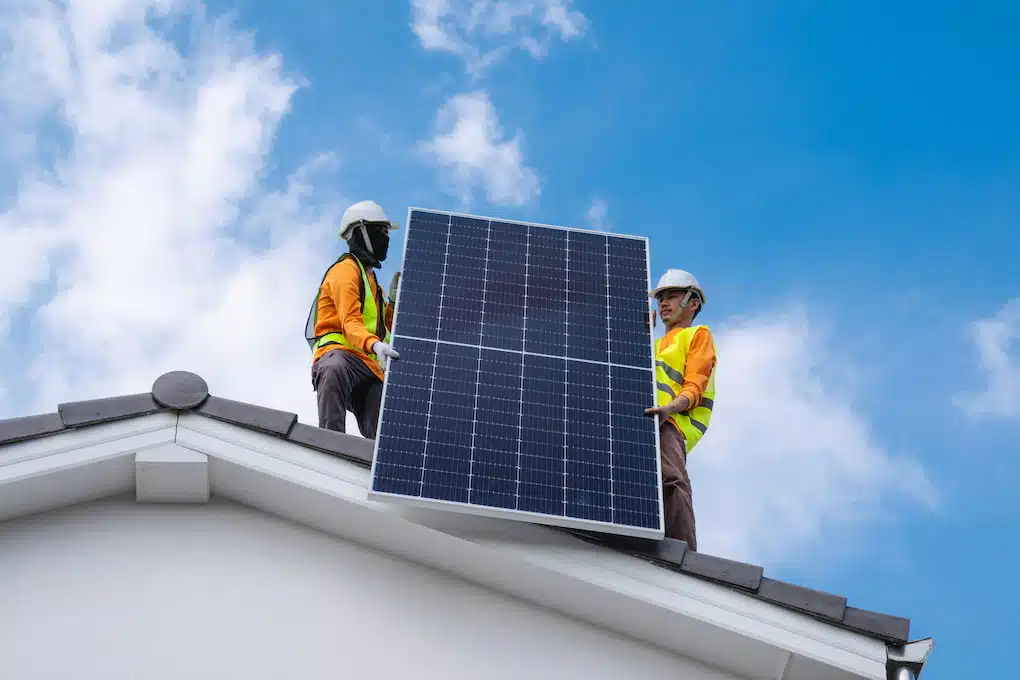 engineers installing solar panels on roof